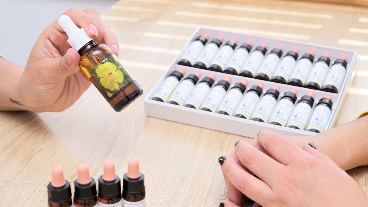 Caja con 38 esencias florales de Bach y una mano eligiendo una esencia