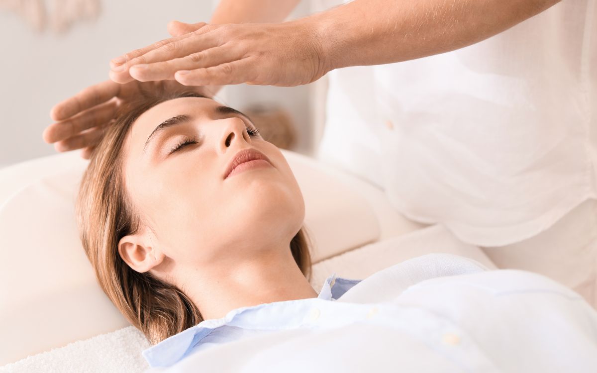 Dona rebent una sessió de Reiki amb imposició de mans al cap